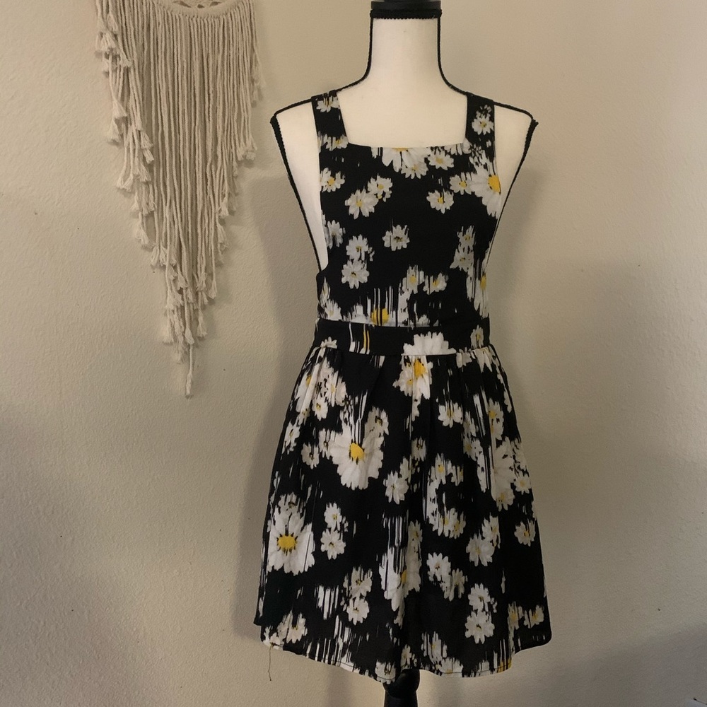 black overall dress with daisy print.